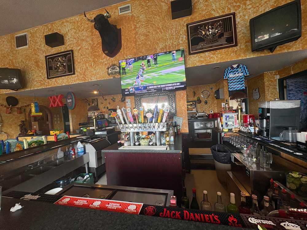 Bar and draft beer taps inside 2 Margaritas Allyn with sports playing on television