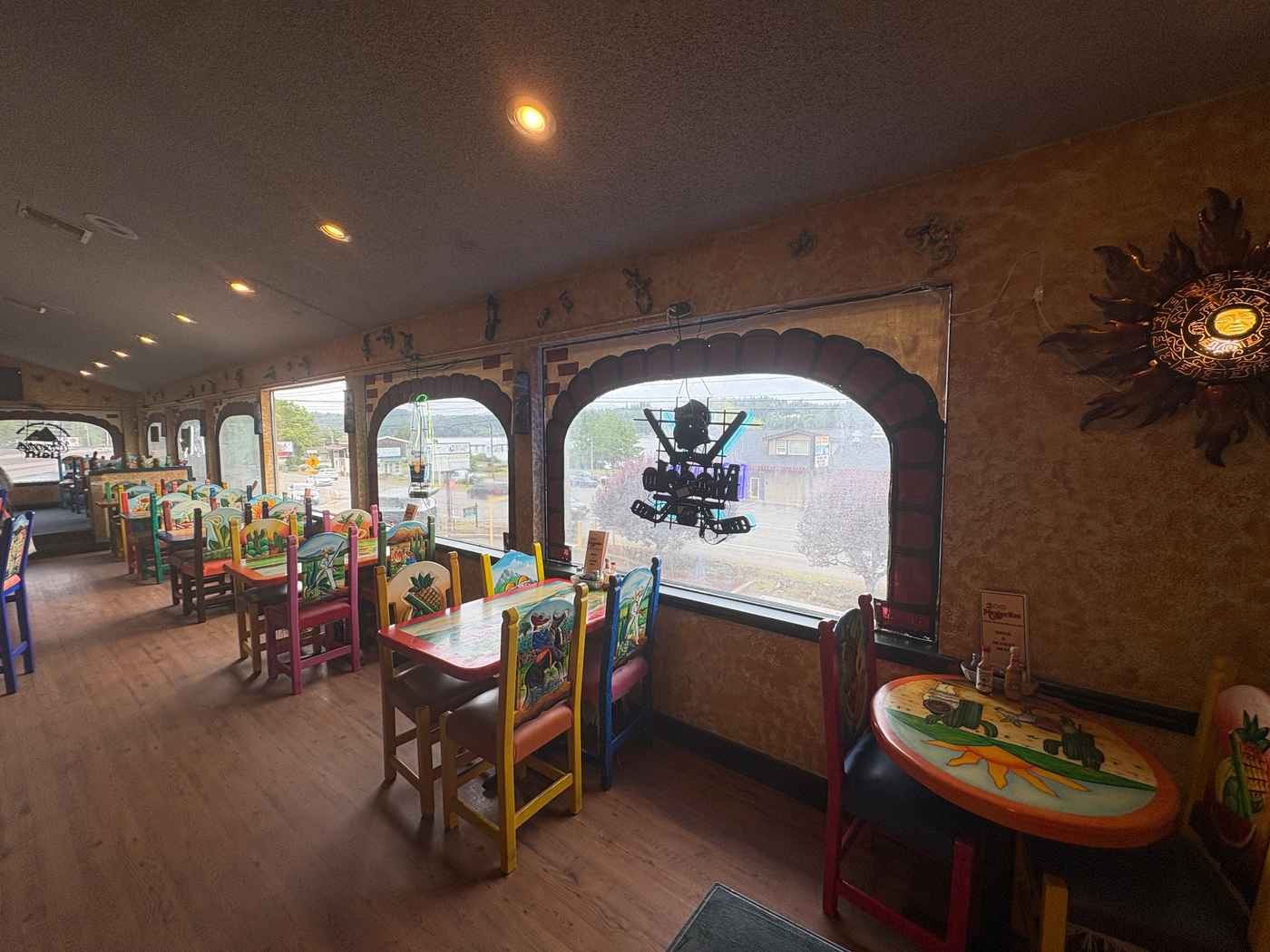 Colorful tables and hand-painted chairs in the bar and lounge dining area at 2 Margaritas Allyn